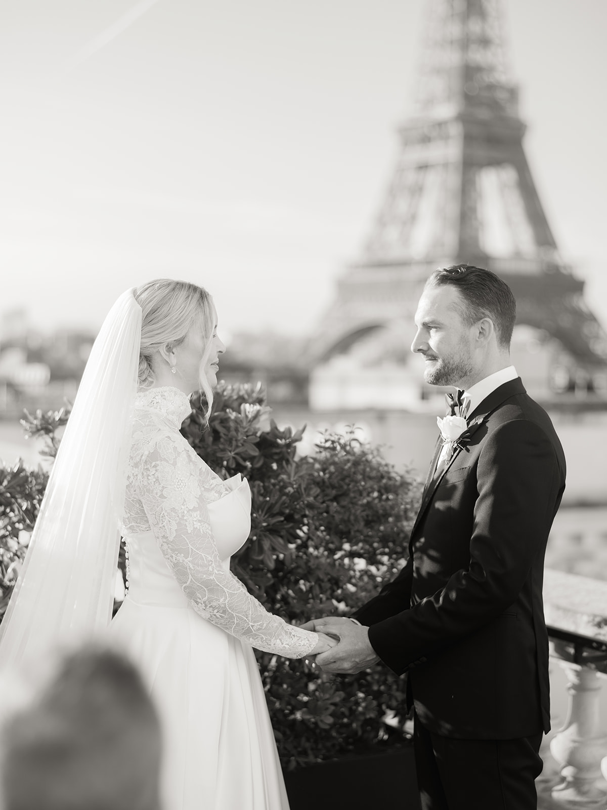 The bride and groom look at each other during the ceremony with a view of the Eiffel Tower
